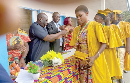 Dr Isaac Danso (2nd from left) being assisted by Eugene Mills, Deputy Director of Education at the Denkyembour District Directorate of Education, to present prizes to outstanding pupils