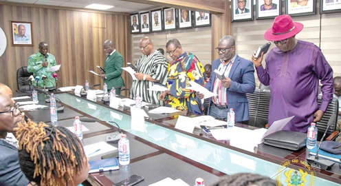 Emmanuel Armah-Kofi Buah (arrowed), Minister of Lands and Natural Resources, swearing in members of the Timber Validation Committee
