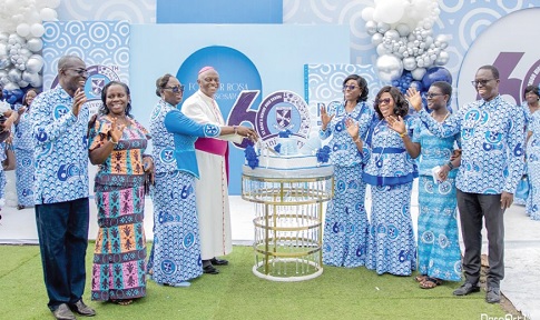Marian Esi Jackson (4th from right), Headmistress, St Rose’s SHS; Most Rev. Joseph Afrifa-Agyekum (4th from left), Bishop of Koforidua Diocese, and some officials of the school after cutting the anniversary cake