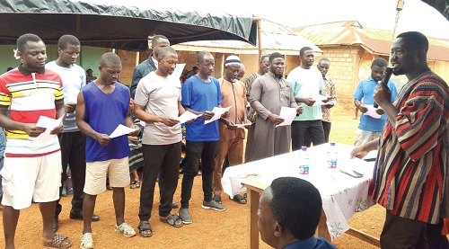 Emmanuel Kwame Frimpong (right), Tano South MCE, swearing in the Brosankro Zonal Council members