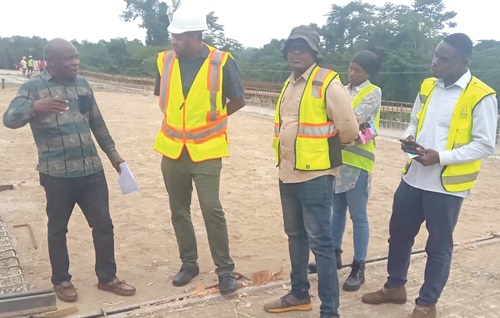 Samuel K. Ofori Larbi (left), Managing Director, Asabea Engineering Limited, interacting with some workers during an inspection of the bridge