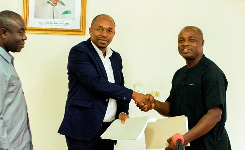 Professor Mawutor (right), Vice-Chancellor, UPSA,  exchanging the signed documents with Philip Gamey, Executive Chairman of Hallmark Research Lab. Looking on is Emmanuel Kwadwo Agyekum, Minister of State in Charge of Special Initiatives 