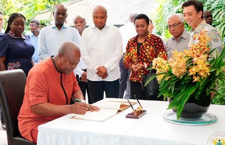 President John Mahama signing a visitors' book at the National Orchid Garden in Singapore