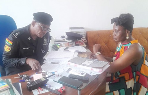 Chief Superintendent Vincent Adotey (left) explaining the details to Beatrice Laryea, Daily Graphic Reporter