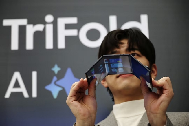 A model poses for photographs with a Galaxy Z TriFold during an event at its store in Seoul, South Korea, December 2, 2025. REUTERS/Kim Hong-Ji