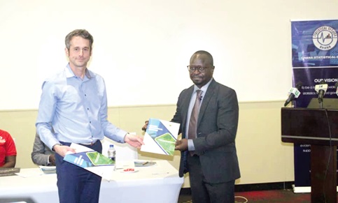 Prof. Kobina Annim (right), Government Statistician, and Dr James Tucker, Deputy Director of Health, International Pertnerships, ONS, UK exchanging  documents
