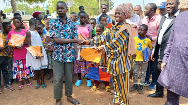 Widad Sayibu, Director of School for Life, presenting uniforms to the pupils