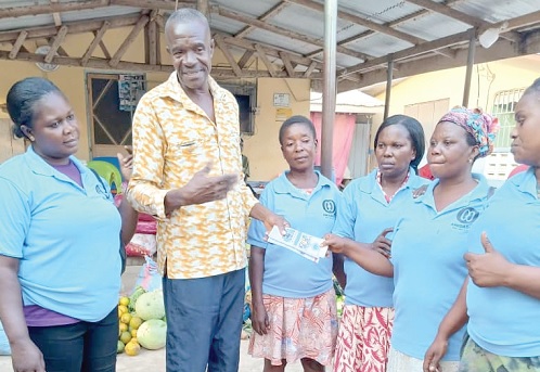 Abena Konadu (2nd from right), Secretary of Anidaso Kuo, presenting an item to Humphrey Patterson Humpatee, a staff at the Countryside Children’s Welfare Home at Bawjiase
