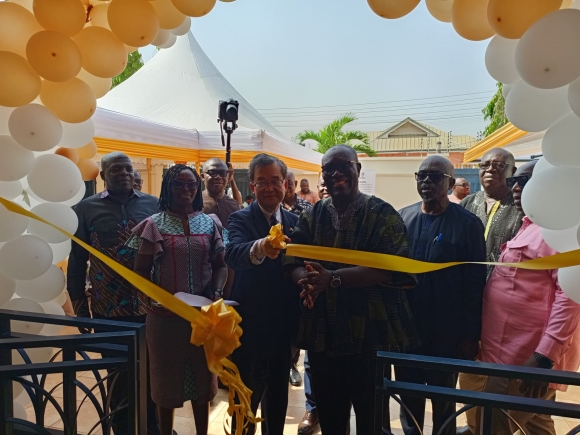 His Execellency Yoshimoto Hiroshi, Japanese Ambassador to Ghana, assisted by Dr Anthony Yaw Baah, Executive Director of Kaizen Institute for Labour Economics cutting the tape to inaugurate the institute. With them as other guests at the event
