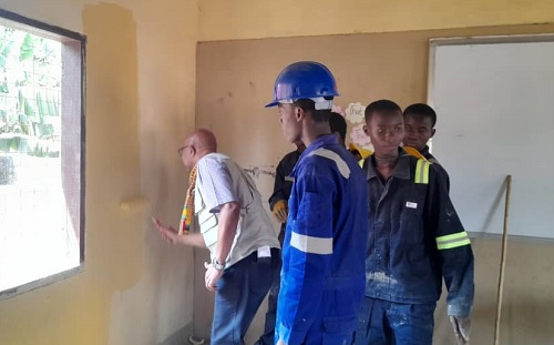  Osama Makkawi, UNICEF Representative in Ghana painting a classroom at Agyemanti M/A Basic School while students of the Akuapem Technical Institute look on