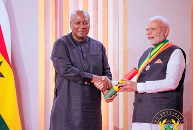 President John Dramani Mahama (left) conferring Indian Prime Minister Narendra Modi with the state honour
