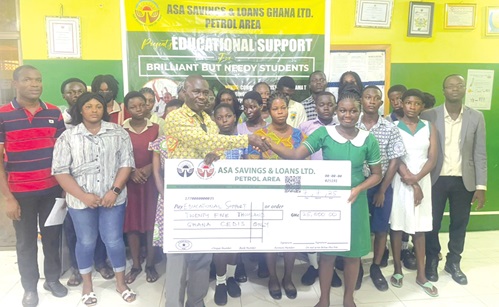 Bennet Tachie Oware, HR officer at the Cape Coast Metropolitan Directorate of Education, presenting a symbolic cheque to Angela Opoku Boateng, one of the beneficiaries