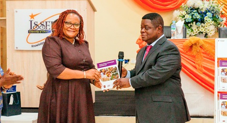 Prof. Peter Quartey (right), Director, ISSER, presenting the newly launched Ghana Social Development Outlook Report 2024 to Mary Awelana Addah, Executive Director, Ghana Integrity Initiative