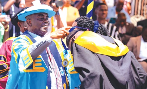 Dr Jethro W Brooks, Jr, acting Vice-Chancellor of the Regional Maritime University, decorating one of the graduands with a medal