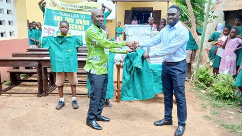 Alfred Sika (right), Kukuo Branch Manager of ASA, presenting the items to Alhassan Abdulai Halidu, Headmaster of A.M.E Zion Primary School