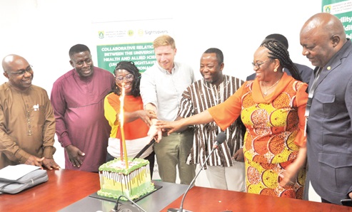 Dr Richard Selby (middle), Sight Savers; Dr Alfred Kwesi Manyeh (2nd from right), Centre for Tropical Diseases, UHAS, and other staff of the university jointly cutting the cake to mark the commencement of the project, while Professor Frank Edwin (left), Pro-Vice-Chancellor of UHAS, looks on