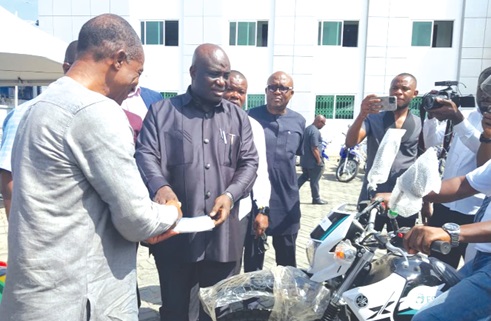 William Dzamefe, the Volta Regional Director of Agric, receiving the key to one of the motorbikes from Eric Opoku, the Minister of Food and Agriculture