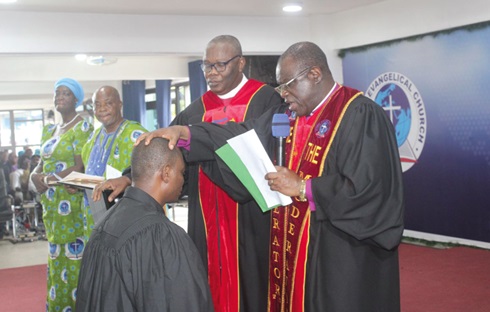 Rt. Rev. Samuel Prosper Dzomeku (right), Moderator of the Global Evangelical Church, and Dr Yohanes K. Ahiabu (left), the Synod Clerk of the church, laying hands on a newly commissioned Minister