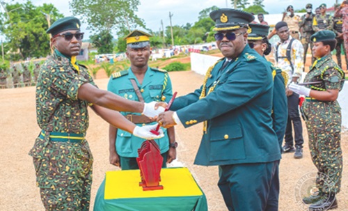 Francis Palmdeti (right), Deputy Commissioner of Immigration, presenting the overall best recruit award to Recruit Officer Mark Selorm Awuku