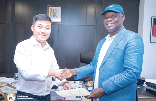 Paul Adjei (right), GETFund Administrator, and Mike Qui Xiaonan, Board member of the Chinese Construction Group, holding the MoU after the signing ceremony