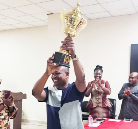 Bismark Otoo, Regional General Manager, Accra East, ECG, with the trophy