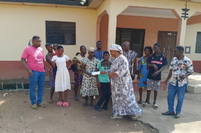 Freda Cooper, Founder and Project Manager of Siblings Project presenting the check to one of the beneficiaries