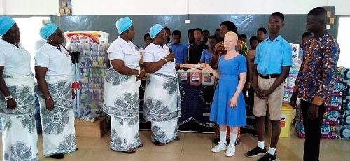 Evelyn Akwatia (4th from left), immediate past Chairperson of the Women’s Fellowship, being assisted by Eugenia Effah-Adu (3rd from left), Chairperson of  the Christ The King Methodist Church, East Legon,  to present the items to the Akropong School for the Blind