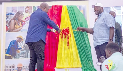 President Mahama being supported by George Opare-Addo (right), Minister of Youth Development and Empowerment, to cut the ribbon to officially launch the programme