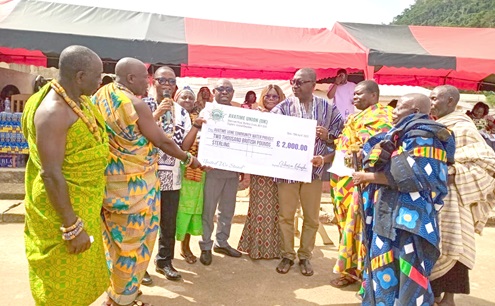 Samuel Aboni (3rd from left), a citizen of Avatime Amedzofe, presenting the dummy cheque of £2,000 to Peter Bosrotsi (4th from right), Chairman of the VACA. Looking on are chiefs, elders and opinion leaders of Avatime Vane 