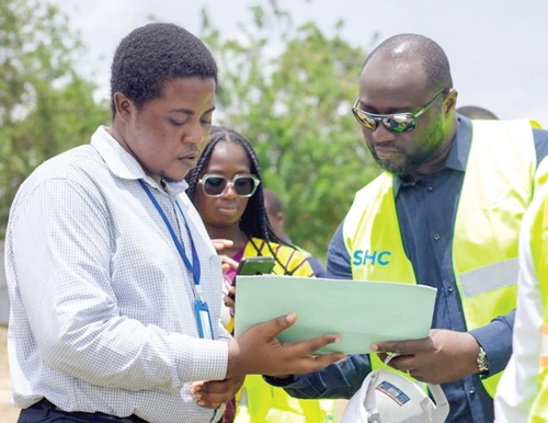 John Bawah (right) being shown some drawings at the Pokuase site