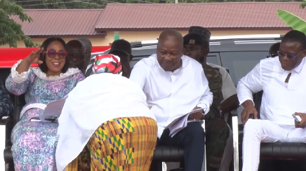 President John Mahama (middle) handing the money to the dancer. With him are Mrs Linda Akweley Ocloo, Greater Accra Regional Minister and Fifi Kwettey, NDC General Secretary