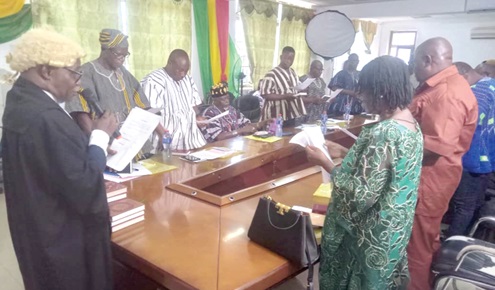  Justice Charles Gyamfi Danquah (left), a Court of Appeal Judge, swearing in the board members of the Lands Commission in the Upper East Region