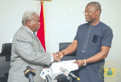 •  Kofi Adams, Minister of Sports and Recreation receiving the report from Mr Amarkai Amarteifio