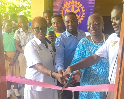 Frank Owusu Adjei (right), President of Rotary Club of Accra, Labone, and Raymond Konney (3rd from right), Headmaster of La Yahoshua Basic School, cutting the ribbon to signify the opening of the washrooms. With them are senior executives of the club. 