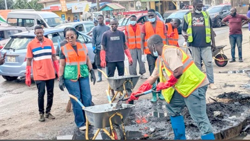 Adamu Musa Kalamu, MCE for Ablekuma North, with a shovel desilting a gutter during the exercise. With him on the left is Ewurabena Aubynn, MP for Ablekuma North.