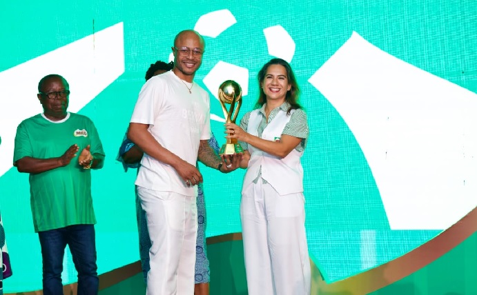 Salome Azevedo, General Manager of Nestlé Ghana and Andre Dede Ayew, one of the ambassadors for the 2025 edition, displaying the trophy at stake 