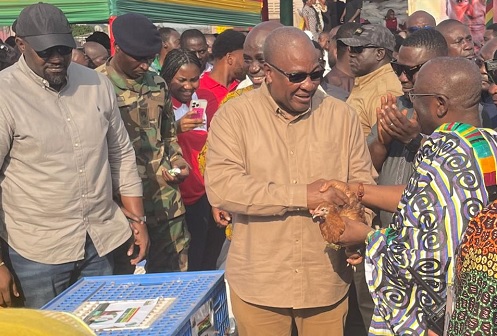President John Dramani Mahama handing over a fowl to Akyamfour Asafo Boakye Agyemang(in Kente), the Asafohene, to officially launch the "Nkoko Nketenkete" initiative in Kumasi. Looking on is John Dumelo(left) , Deputy Minister of Food and Agriculture. Picture: EMMANUEL BAAH