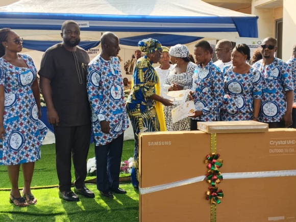 Hajia Katumi Atta Natogmah,(4th left)  Greater Accra Regional Director of Education,  presenting the award of overall best teacher in the Krowor Municipality to  Mr Patrick Kartey Addonor, a teacher at the Nungua Presbyterian Junior High School. With them are Mr Azeriya G Ayeriga, (3rd left) Krowor Municipal Director of Education, Paul Afotey Quaye, (2nd left) MCE for Krowor Municipal Assembly and other teachers