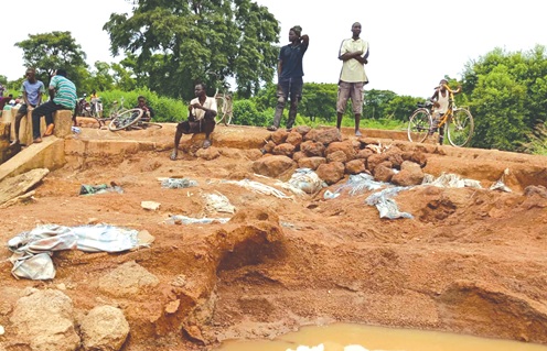 Residents fixing portions of the deplorable road with stones Residents fixing portions of the deplorable road with stones