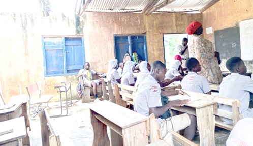 Pupils studying in a classroom with part of its roof ripped off Pupils studying in a classroom with part of its roof ripped off