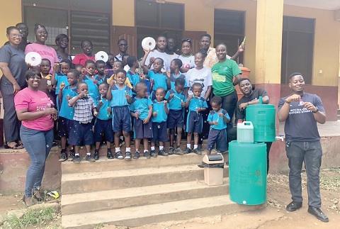 Mavis Maku Addo (left), President of Rotaract Club of Accra Labone, and Iddriss Zuberu (right), President of Rotaract Club of Accra Osu Oxford Street, and other club members with some teachers and pupils after the sensitisation