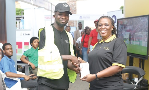 Gloria Adutwumwaa-Frimpong (right), Senior Manager, Data Devices and Home, MTN, presenting a Samsung Galaxy phone to Emmanuel Annang, the winner of the raffle game at the Daily Graphic-GREDA Home Fair held in Accra. Pictures: BENEDICT OBUOBI