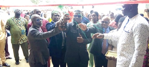 Emmanuel Adotey Allotey (middle), the Ga Central Municipal Chief Executive, cutting the tape to inaugurate the facility. INSET: The 18-unit classroom block