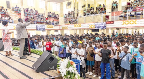 The school leavers being led in prayer