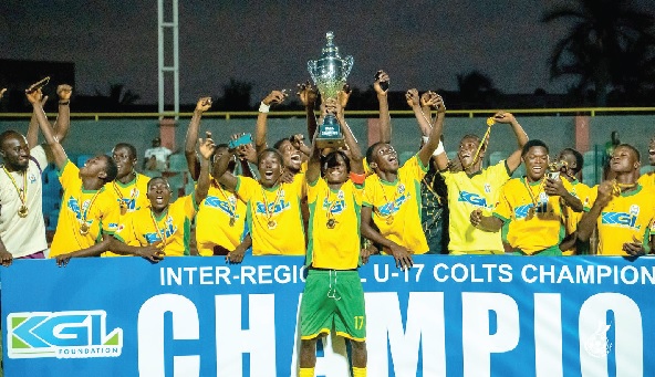 Players of the Ashanti Region team celebrating with the winner's trophy and medals