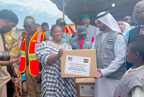 Rashid Al Shamsi (right), executive director, UAE Aid agency, presenting a box of relief items to a flood survivor