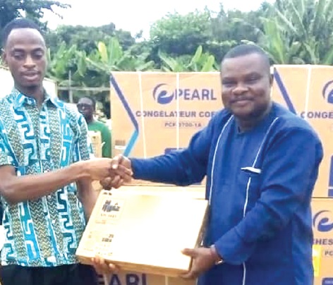 Nicholas Owen Korletey (right), Presiding Member for the Shai-Osudoku District Assembly,  presenting a laptop to Maxwell Tettey