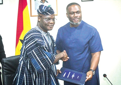 Kenneth Gilbert Adjei, immediate past Minister of Works, Housing and Water Resources, handing over responsibilities to Ahmed Ibrahim (left), the new sector Minister, while some directors and officials of the Ministry applaud at the ceremony. Picture: ERNEST KODZI