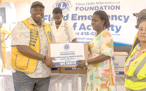 Ebo Prah Manson (left), the District Governor of the Club, presenting a box of items to a beneficiary