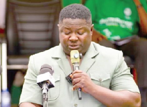 Issifu Yakubu (inset), MCE for Mampong Municipal Assembly, delivering his speech during the programme with some of the items ready for distribution on display